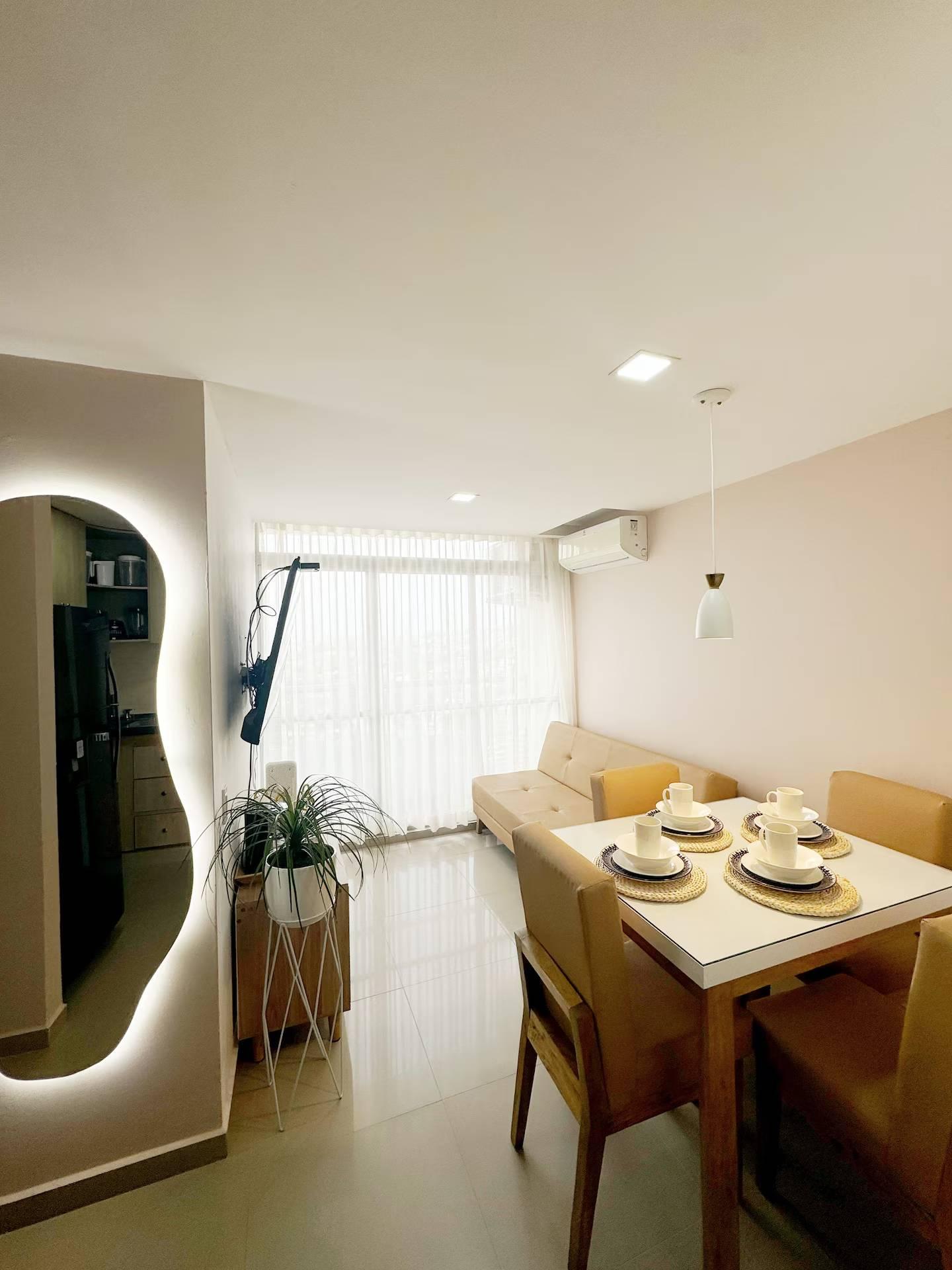 Comedor moderno con mesa de madera y cocina integrada en apartamento de Cartagena de Indias