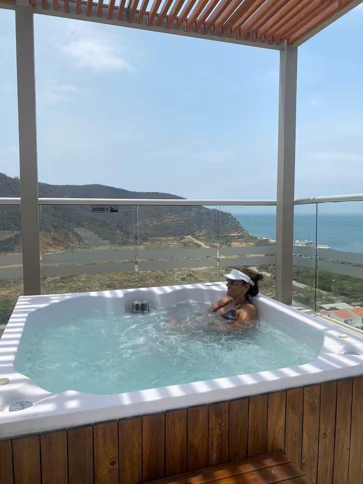 Jacuzzi privado en balcón con vista al mar y montañas en apartamento Salguero Suites Gaira